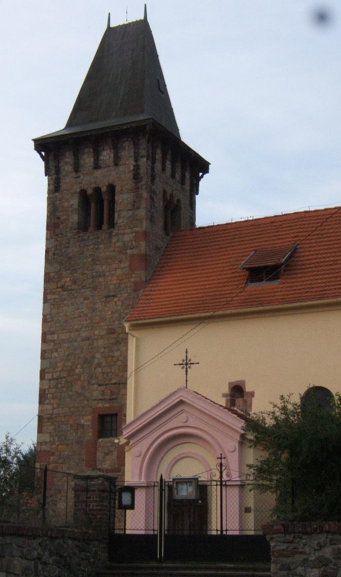 Věž se sdruženými okny a zazděným vstupem. 
Nad vchodem románské a současné okno.